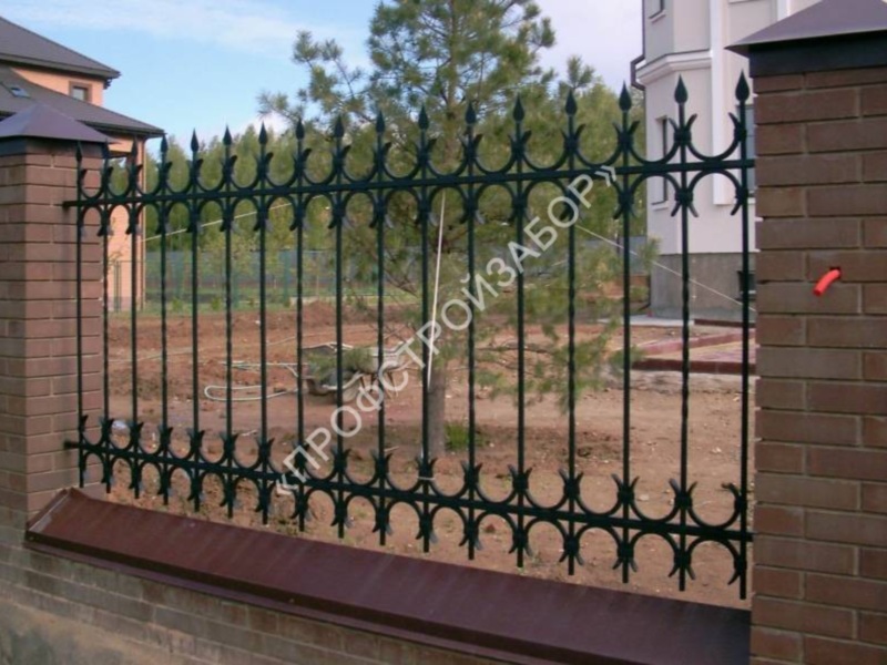 Металлический кованый забор с кирпичными столбами